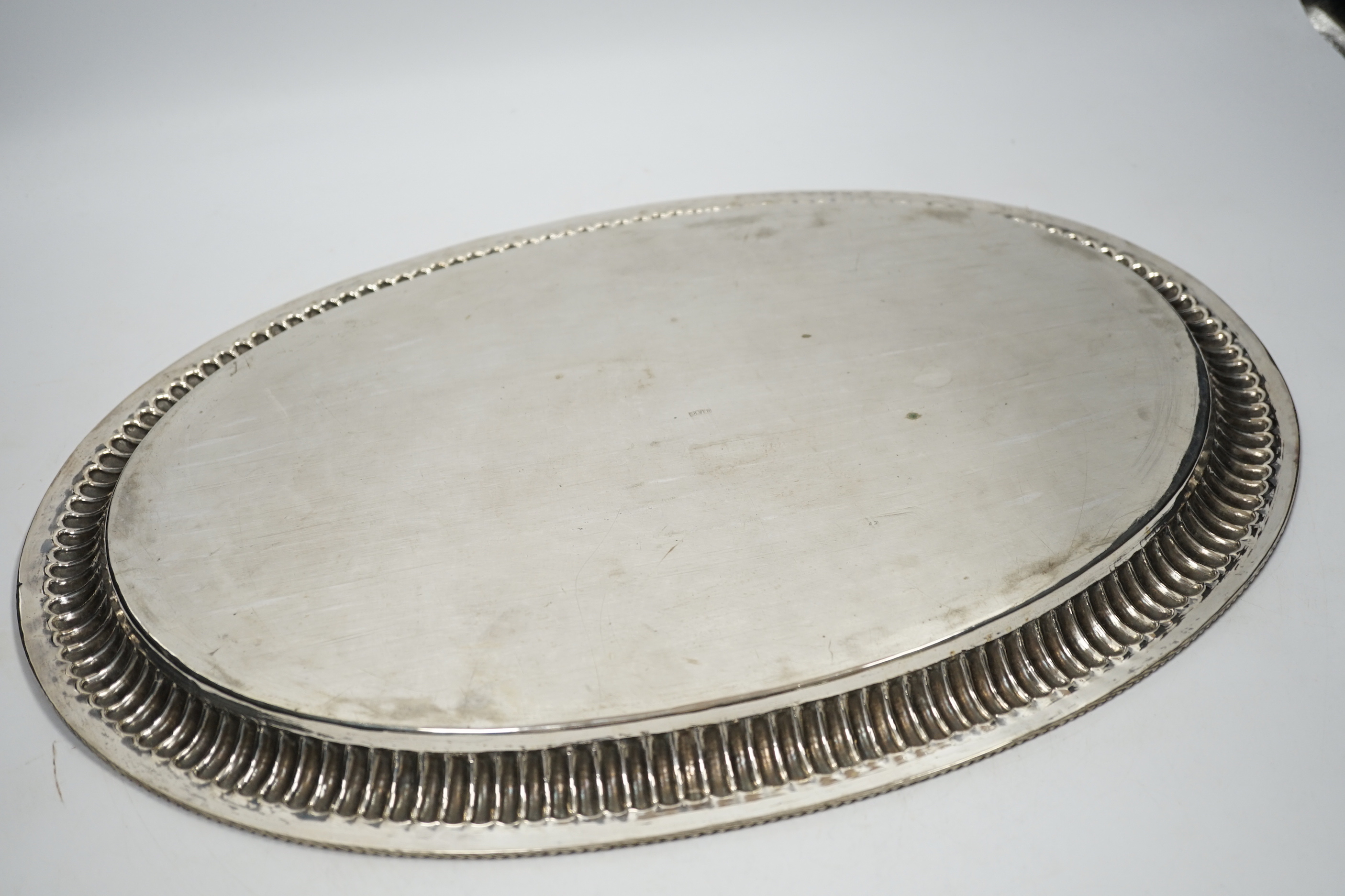 A Far Eastern white metal oval tray, with gadrooned and beaded rim, stamped silver, 45cm